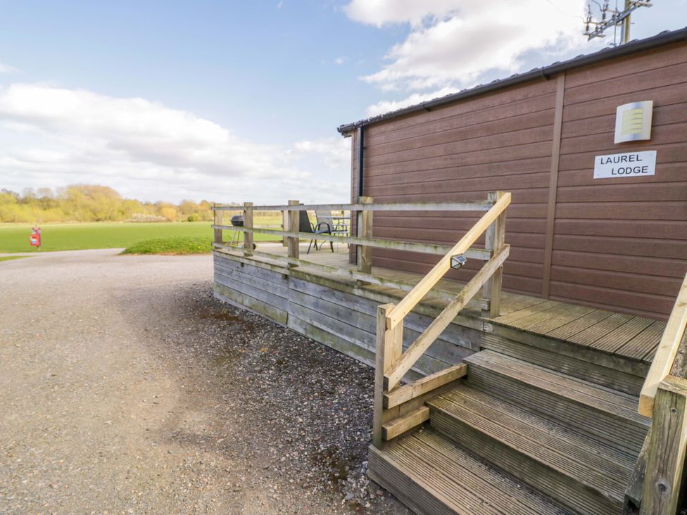 A deck with steps and a chair at Laurel Lodge Offenham