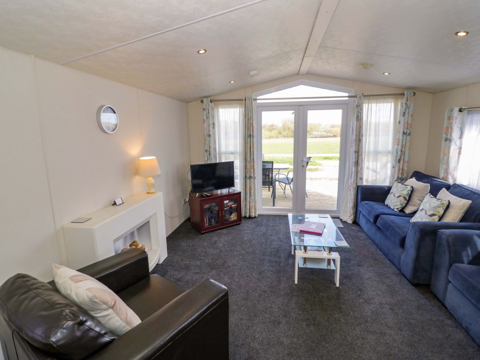 A living room with a sofa and television at Laurel Lodge Offenham