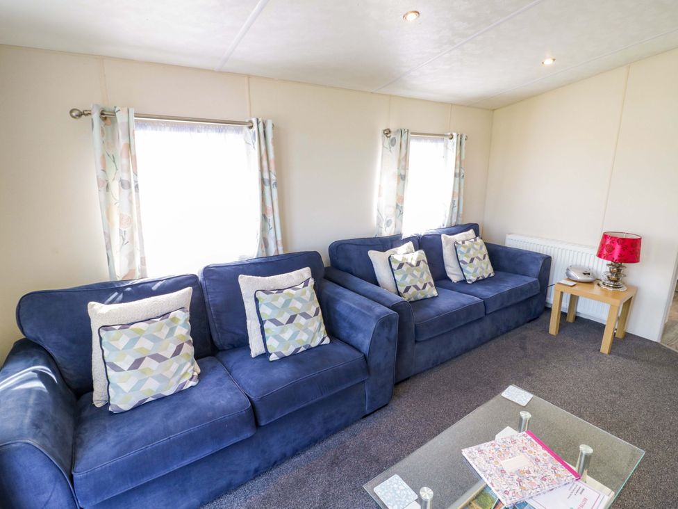 A living room with sofas and a lamp at Laurel Lodge Offenham