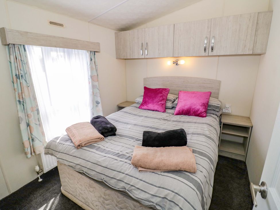 A bedroom with a bed and bedside table at Laurel Lodge Offenham