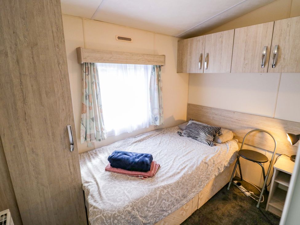 A bedroom with a bed and storage at Laurel Lodge in Offenham