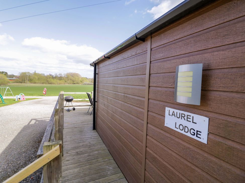 An outdoor area with a deck and sign at Laurel Lodge Offenham