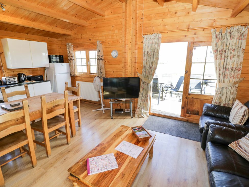 A living room with a sofa and dining table at Oak Lodge Offenham