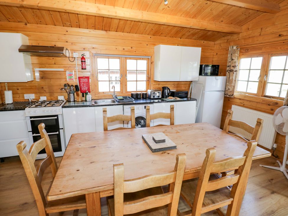 A kitchen with table and chairs at Oak Lodge in Offenham