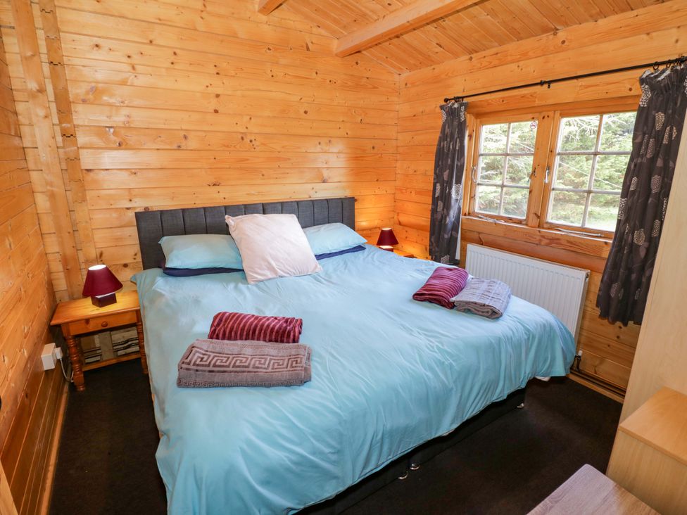 A bedroom with a bed and a window at Oak Lodge Offenham