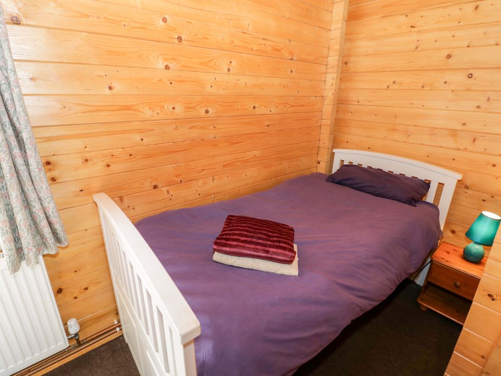 A bedroom with a single bed and a bedside table at Oak Lodge Offenham