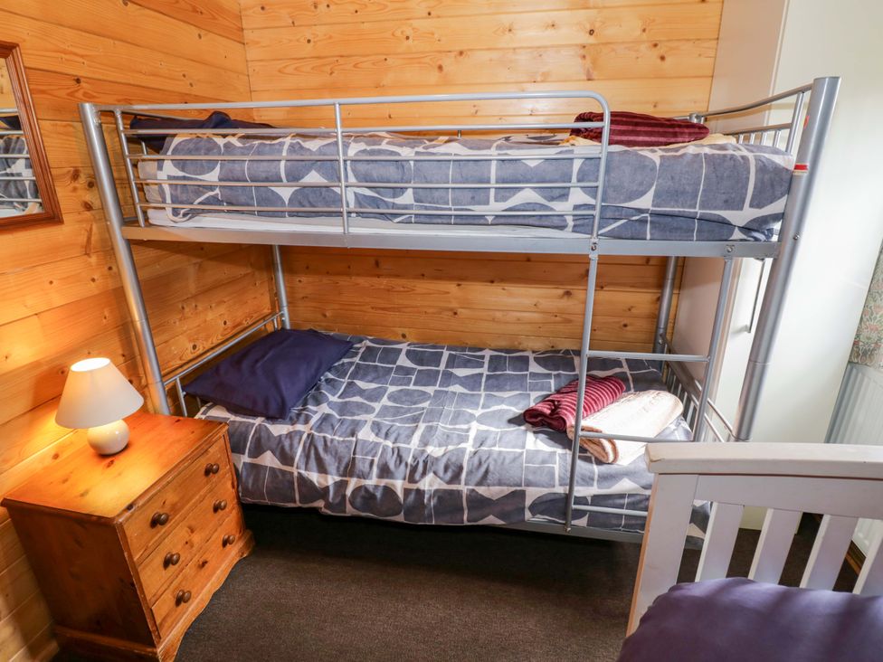 A bedroom with a bunk bed and a lamp at Oak Lodge Offenham