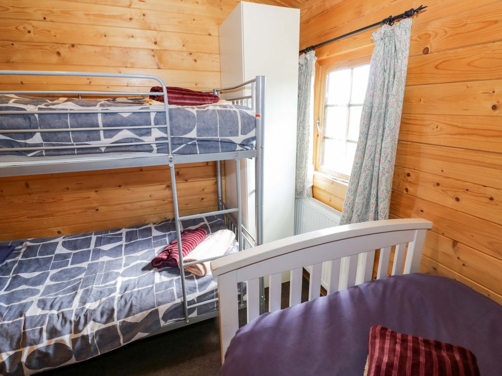A bedroom with bunk beds and a single bed at Oak Lodge in Offenham