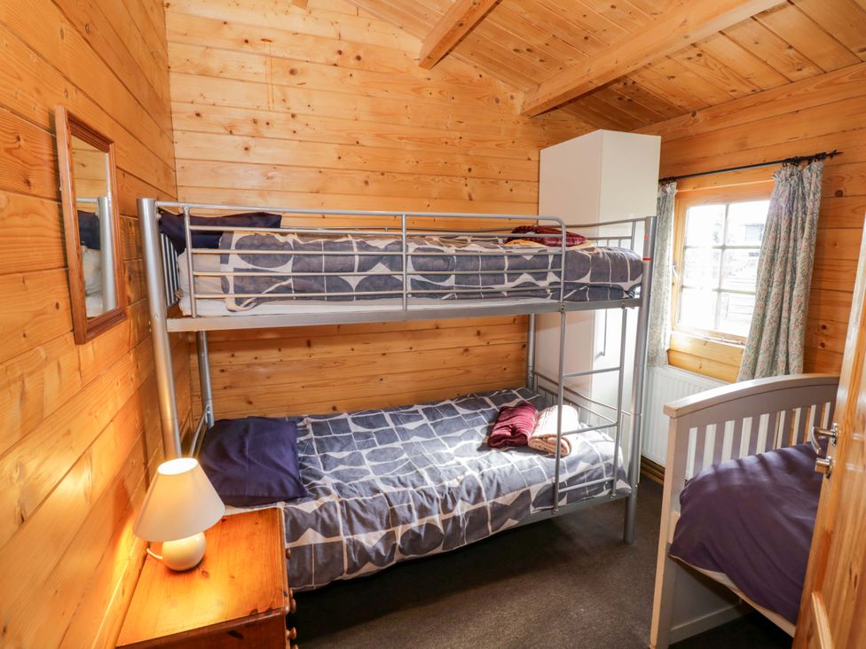 A bedroom with bunk beds and a single bed at Oak Lodge Offenham