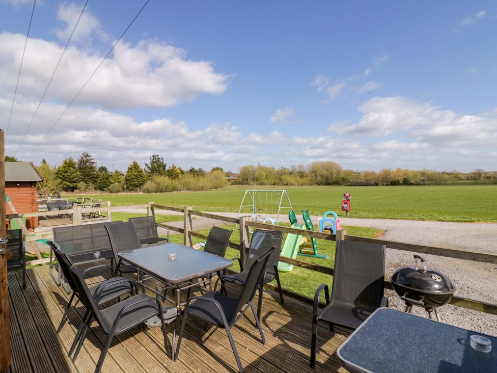 An outdoor seating area with a table and chairs at Oak Lodge in Offenham