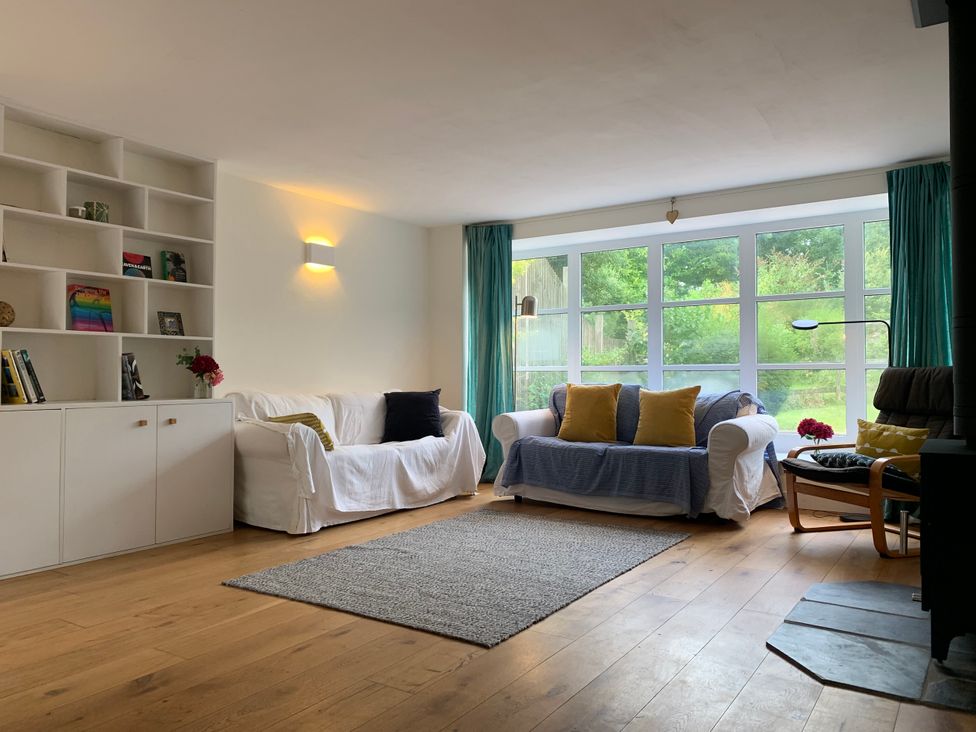 A living room with windows and a couch at Chantry Studio in Kingsbridge