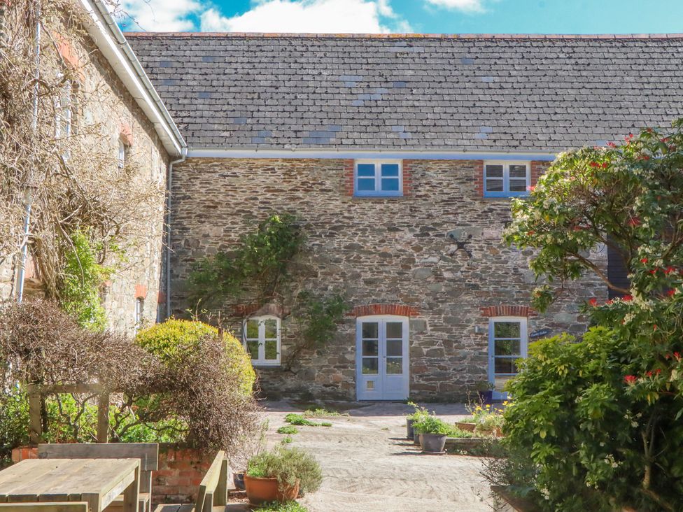 An outdoor area with stone building and garden features at Chantry Studio in Kingsbridge