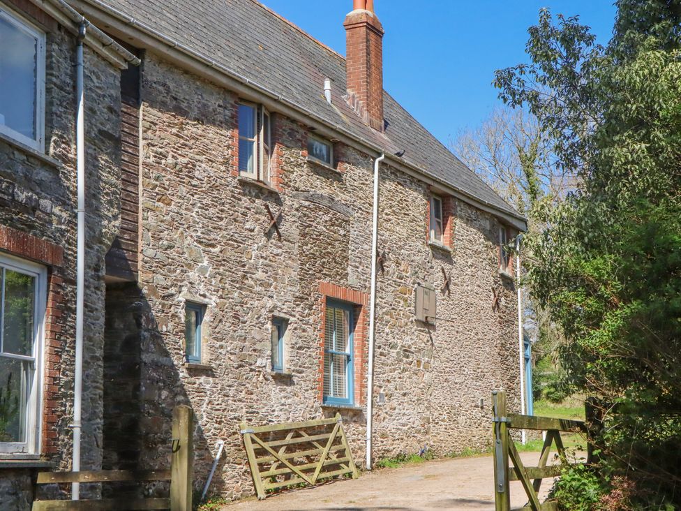 A stone exterior with windows and a gate at Chantry Studio in Kingsbridge