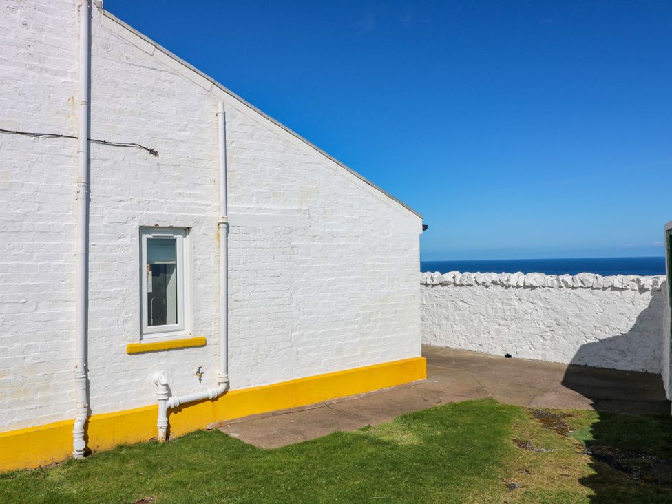 An outdoor area with a wall and window at The Lighthouse Bothy St Abbs