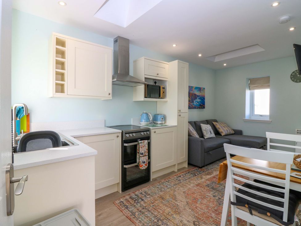 A kitchen with cabinets and appliances at The Lighthouse Bothy in St Abbs