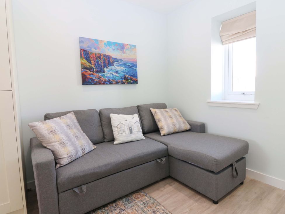 A living room with a sofa and artwork on the wall at The Lighthouse Bothy St Abbs
