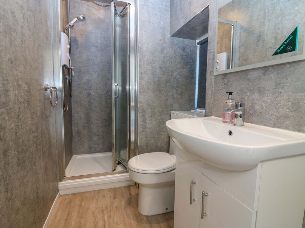 A bathroom with a shower, toilet, and sink at The Lighthouse Bothy in St Abbs
