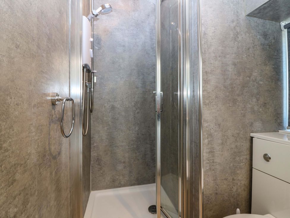 A shower area with glass doors at The Lighthouse Bothy in St Abbs