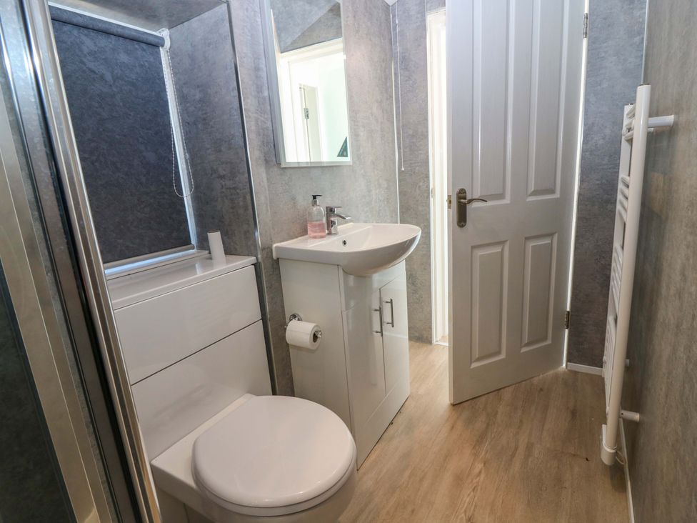 A bathroom with a sink, toilet, and shower at The Lighthouse Bothy in St Abbs