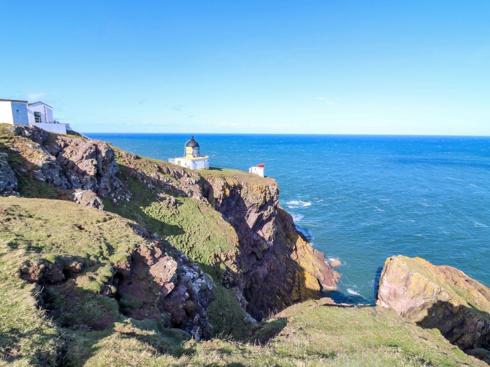A lighthouse on cliffs overlooking the ocean at The Lighthouse Bothy in St Abbs