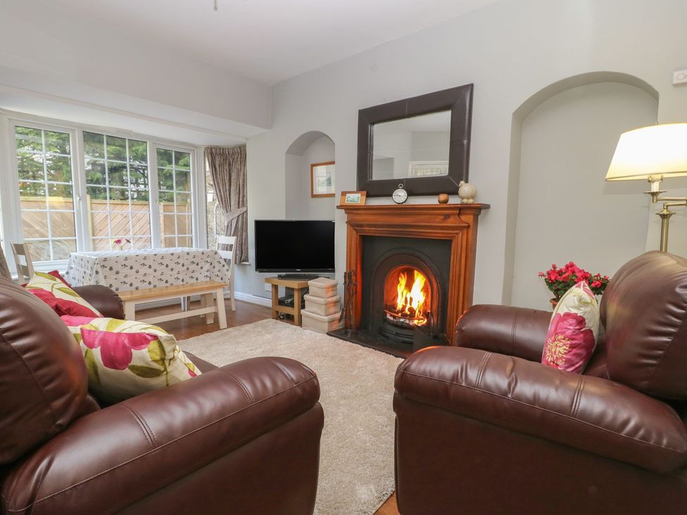 A living room with a fireplace and a television at Wedgewood Cottage in Middleham