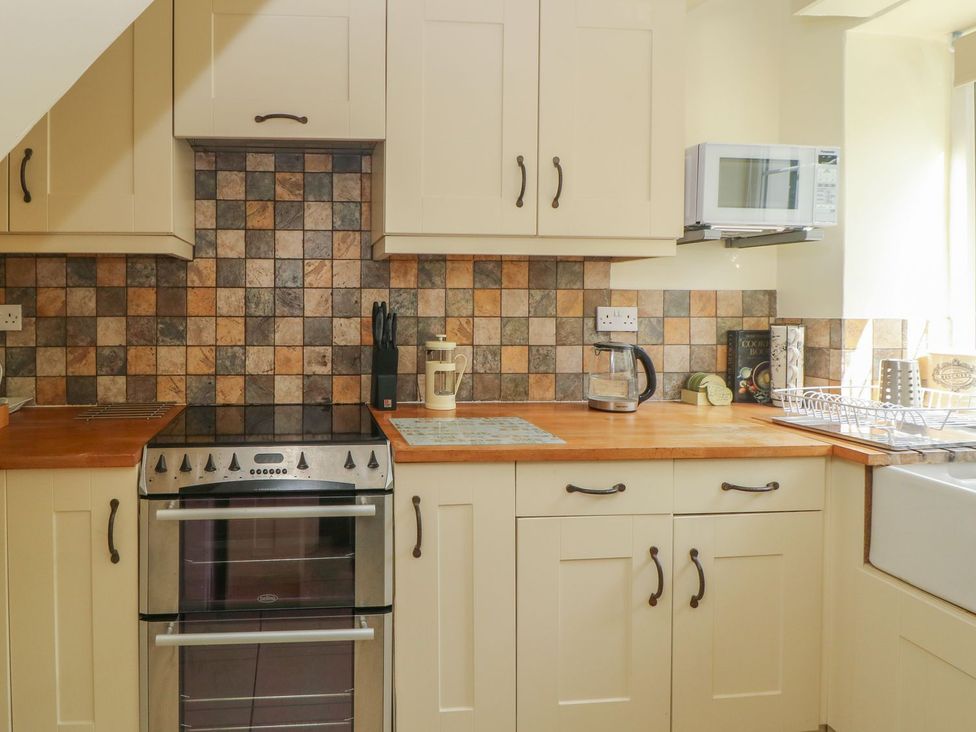 A kitchen with a stove and microwave at Wedgewood Cottage in Middleham