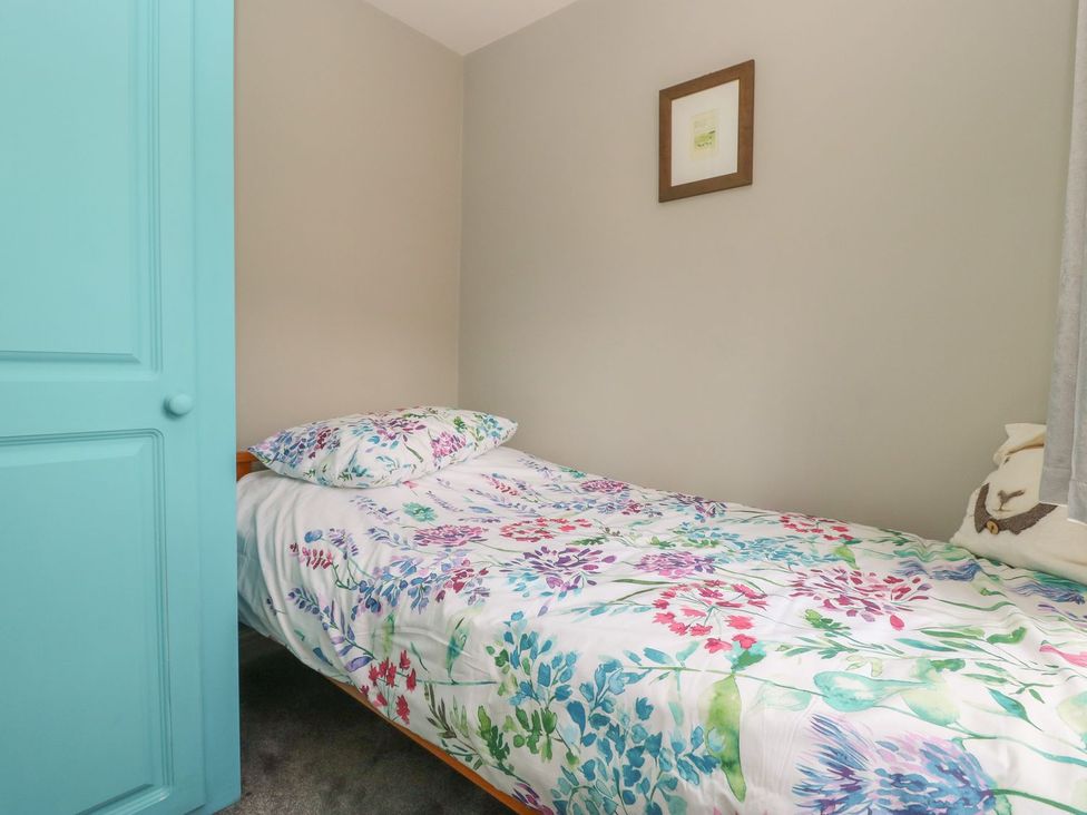 A bedroom with a bed and decorative frame at Wedgewood Cottage in Middleham