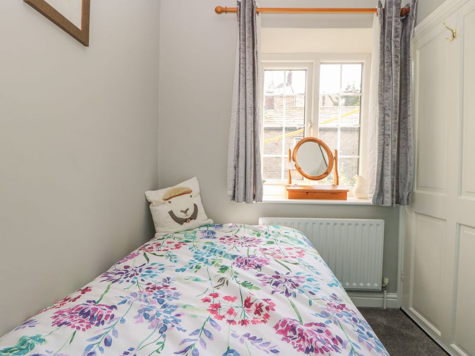 A bedroom with a bed and a window at Wedgewood Cottage in Middleham