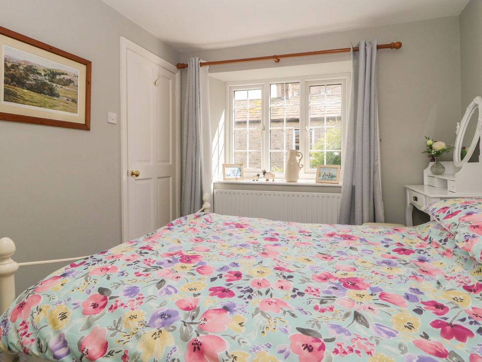 A bedroom with a bed and window at Wedgewood Cottage in Middleham