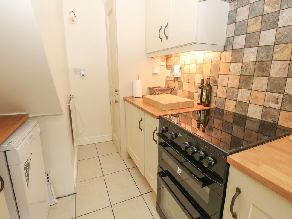 A kitchen with a stove and counter at Wedgewood Cottage in Middleham
