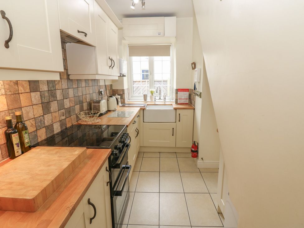 A kitchen with cabinets and a sink at Wedgewood Cottage in Middleham