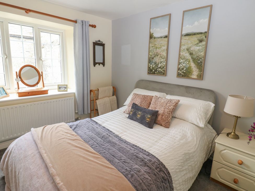 A bedroom with a bed and a window at Wedgewood Cottage in Middleham