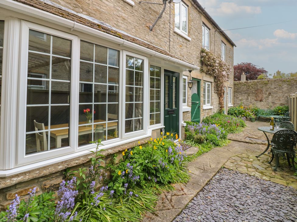 An outdoor area with flowers and seating at Wedgewood Cottage in Middleham