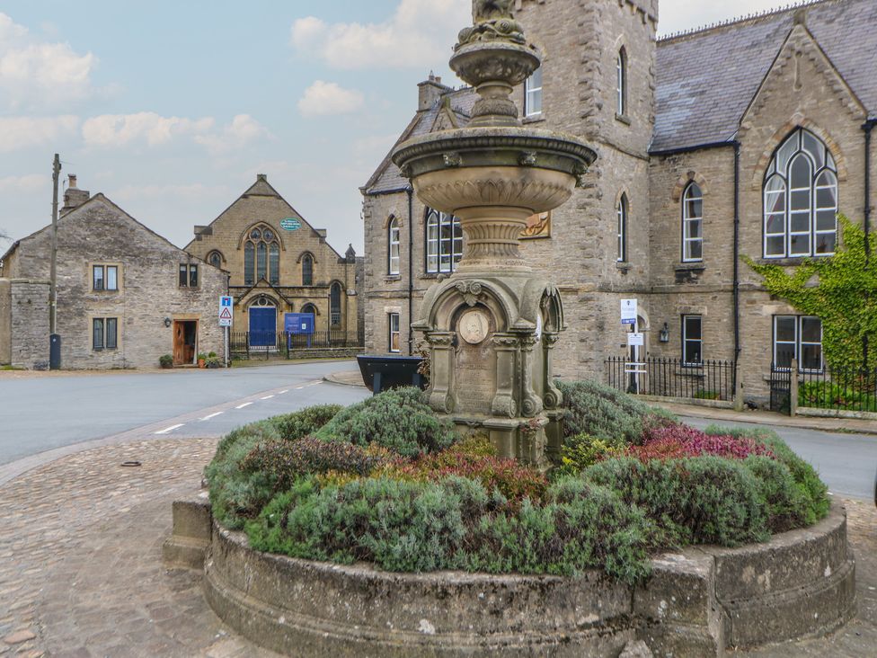 A fountain surrounded by bushes in a street at Wedgewood Cottage in Middleham