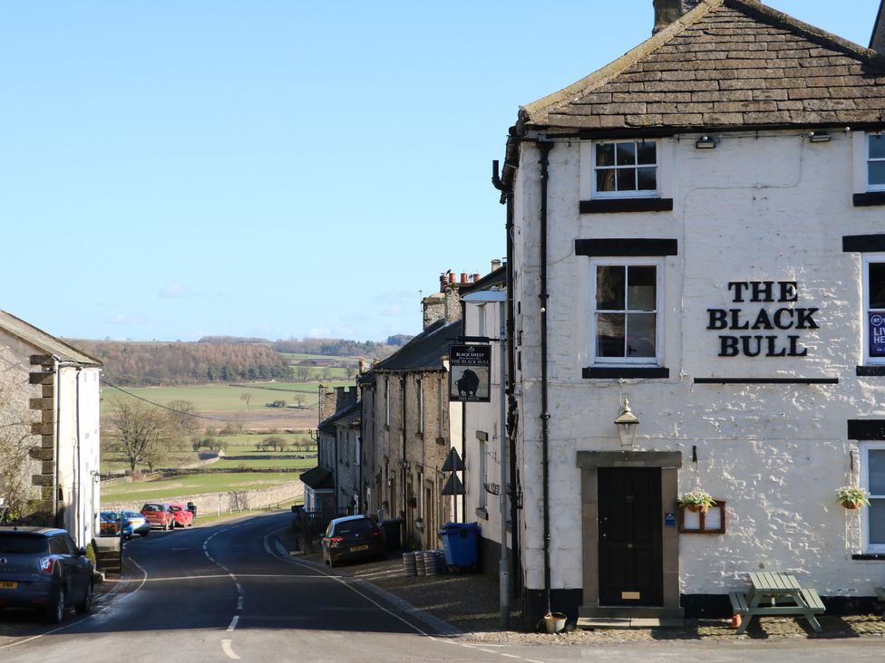 A pub named The Black Bull with vehicles on the street in Middleham