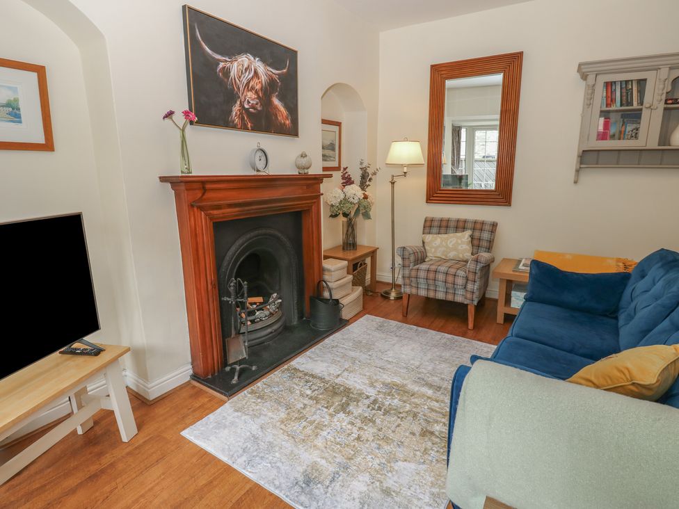 A living room with a fireplace and sofa at Wedgewood Cottage in Middleham