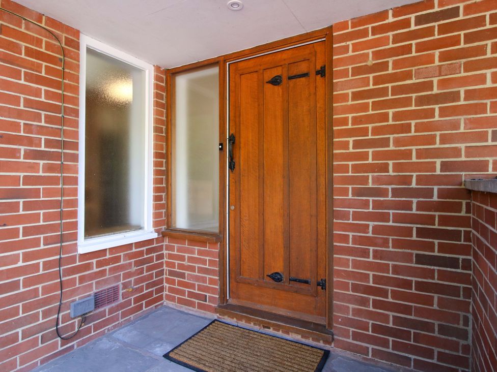 An entryway with a wooden door and window at Westington Hall in Hatfield near Bromyard
