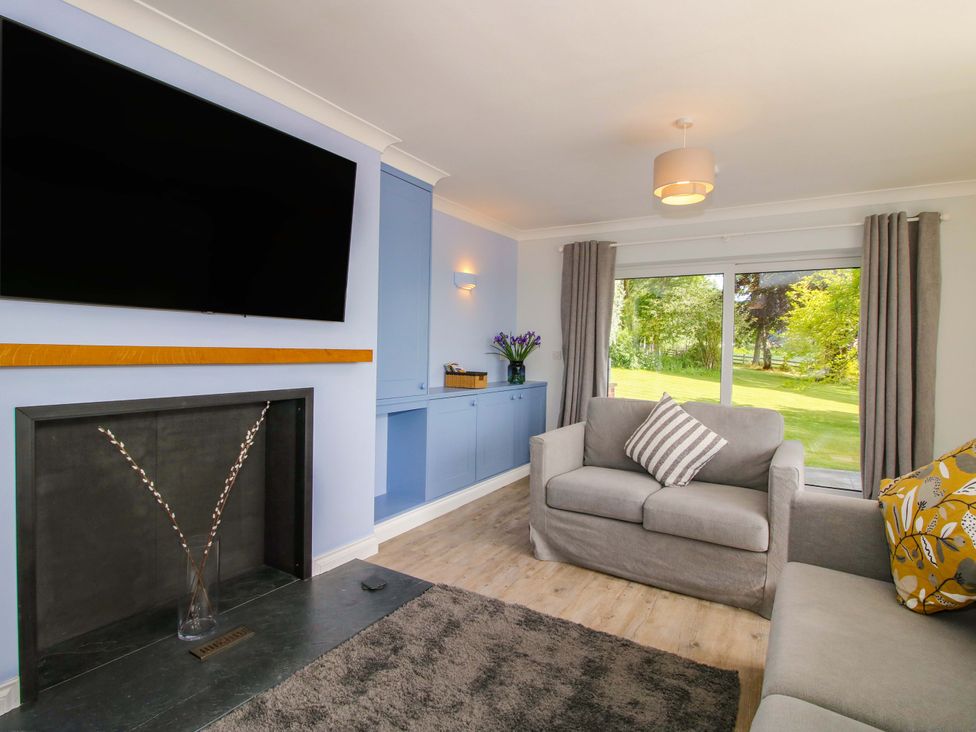 A living room with a television and sofa at Westington Hall in Hatfield near Bromyard