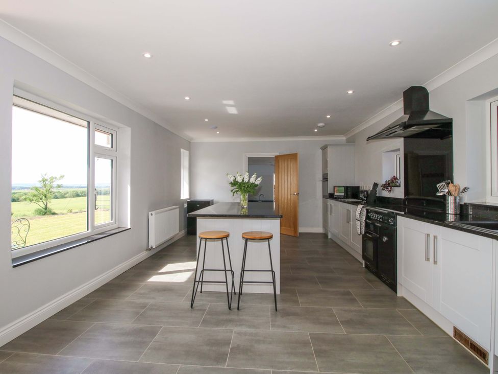 A kitchen with a kitchen island and bar stools at Westington Hall in Hatfield near Bromyard