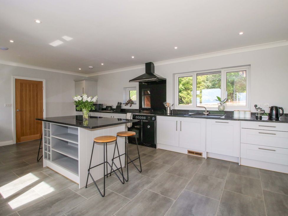 A kitchen with an island and stools at Westington Hall Hatfield near Bromyard