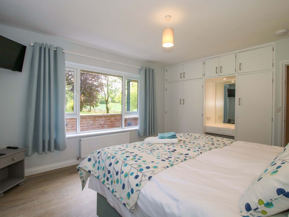 A bedroom with a bed and wardrobe at Westington Hall in Hatfield near Bromyard