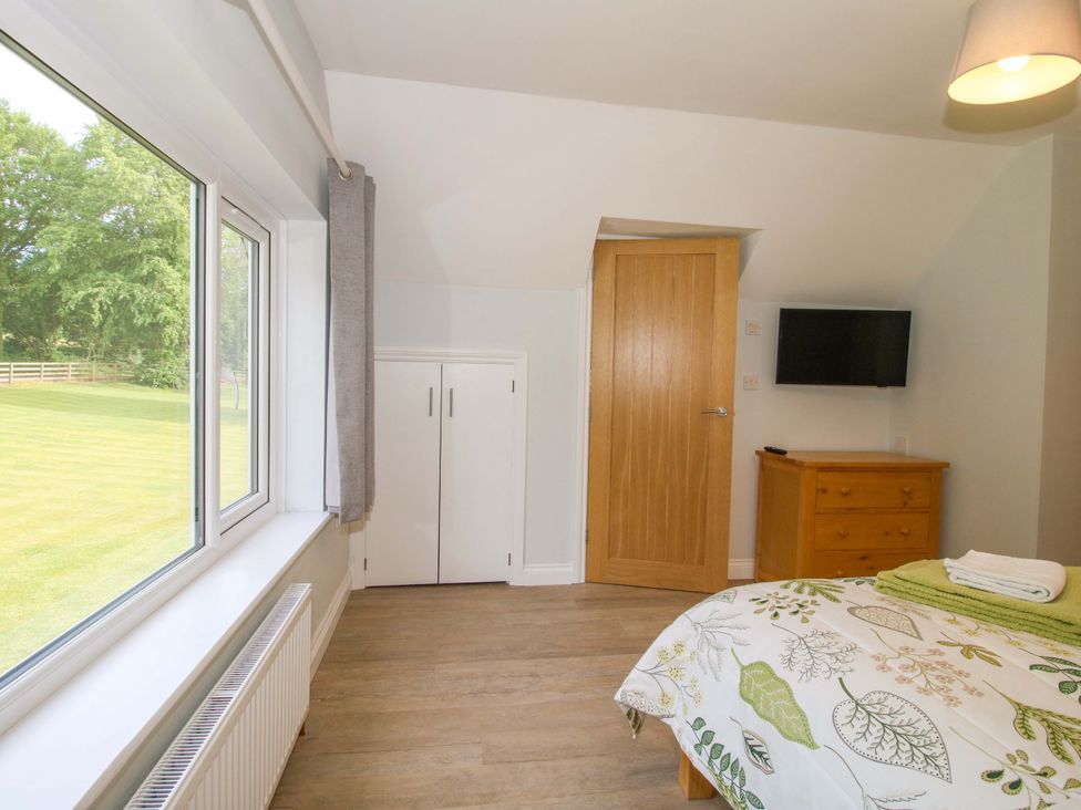 A bedroom with a window and a wardrobe at Westington Hall in Hatfield near Bromyard
