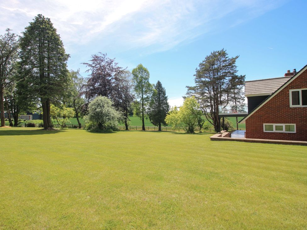 An outdoor area with a lawn and trees at Westington Hall in Hatfield near Bromyard