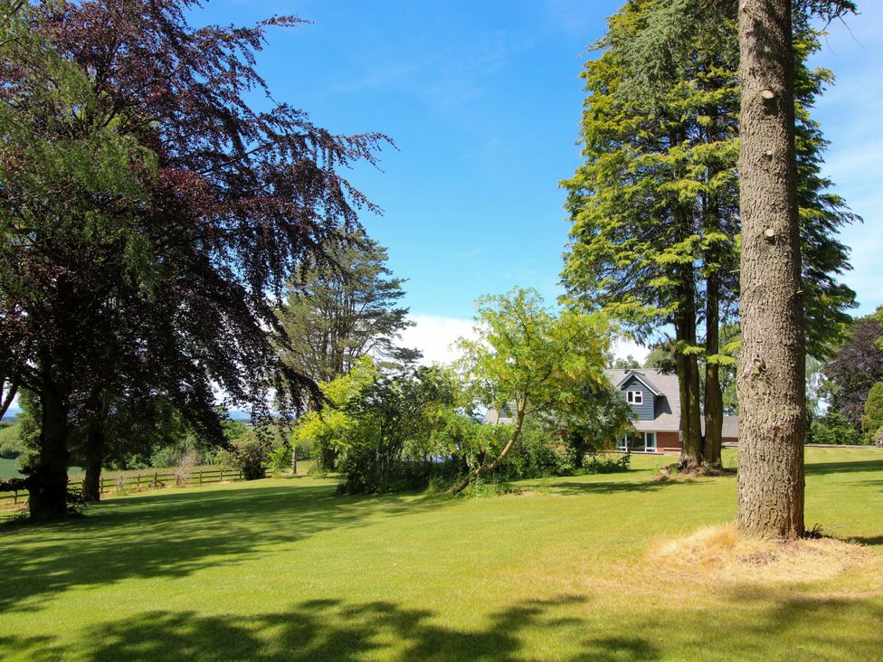 A garden with trees and a house at Westington Hall in Hatfield near Bromyard