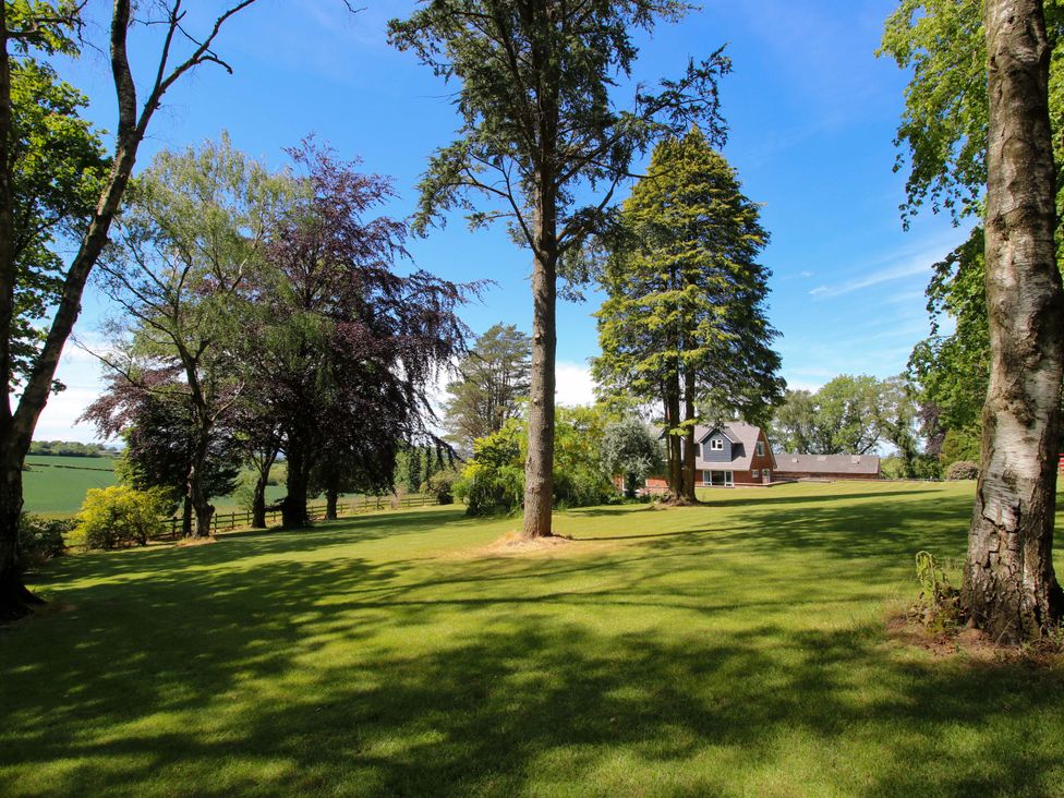 A garden with trees and a house at Westington Hall Hatfield near Bromyard