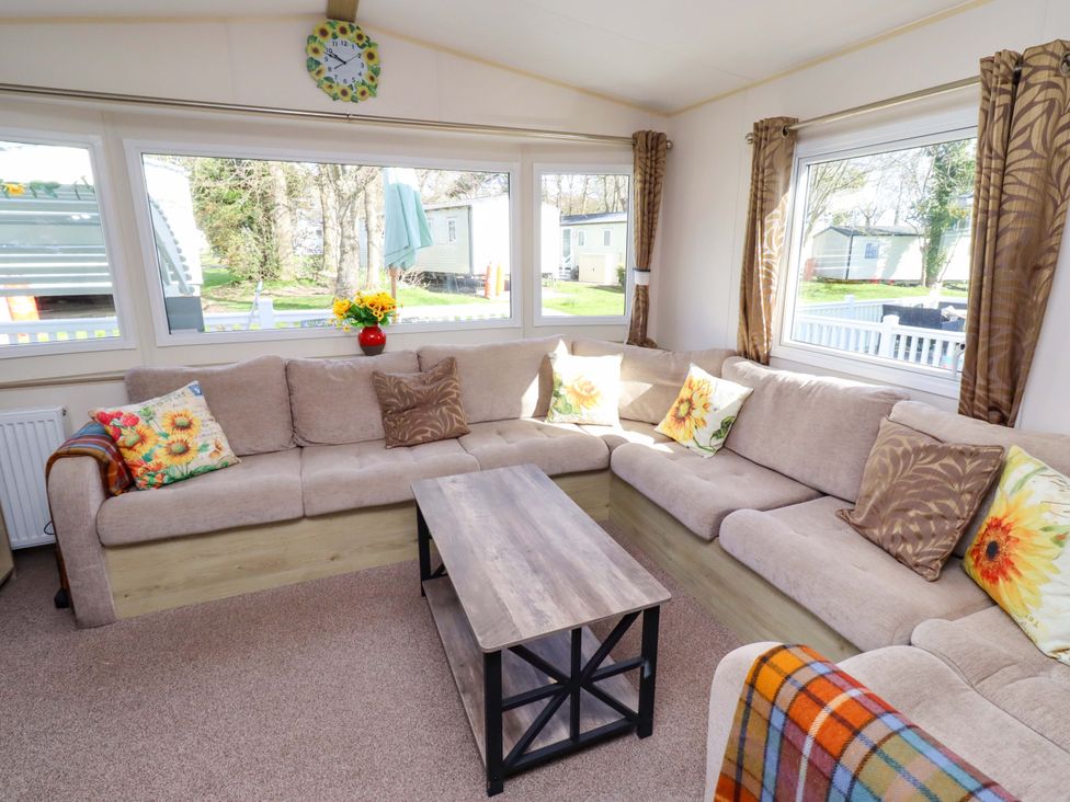 A living room with a sofa and coffee table at Sunflower Retreat, Caravan 61