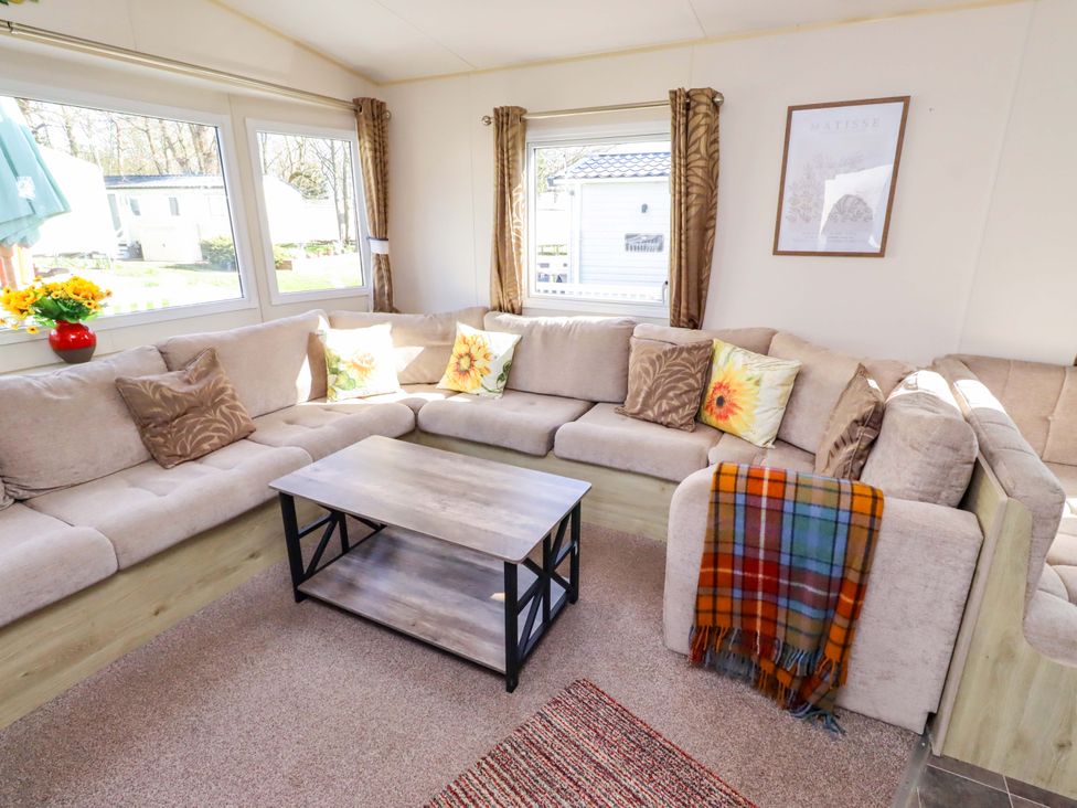 A living room with a sofa and coffee table at Sunflower Retreat, Caravan 61