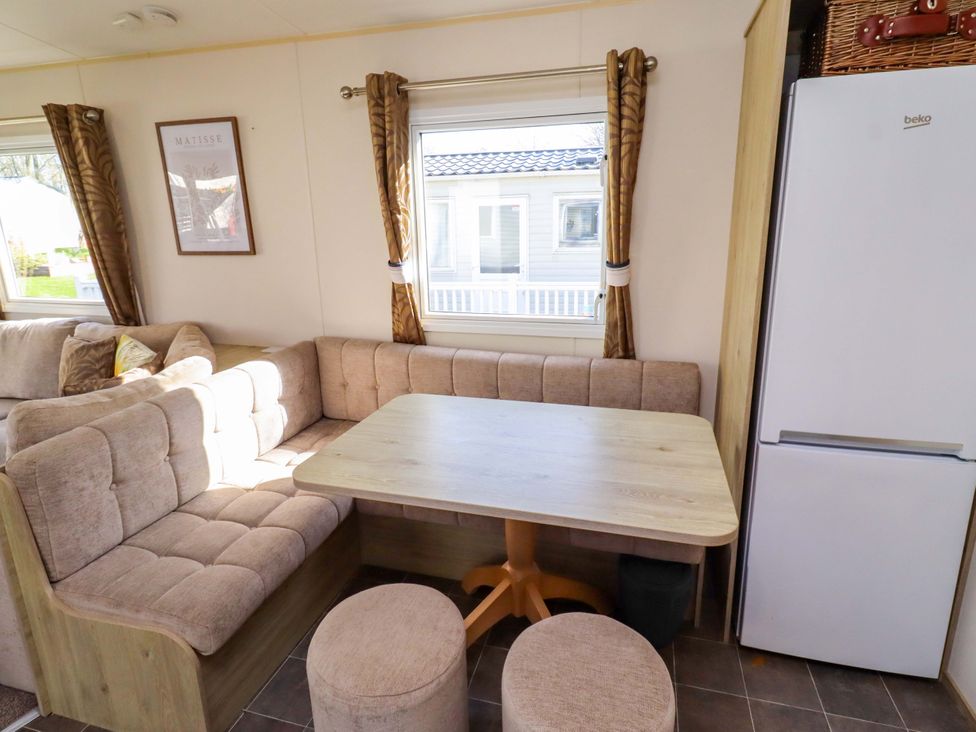 A living room with a table and sofa at Sunflower Retreat, Caravan 61