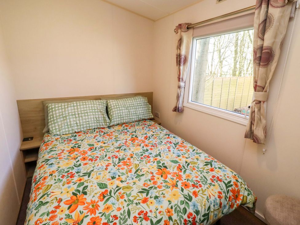A bedroom with a bed and window at Sunflower Retreat, Caravan 61