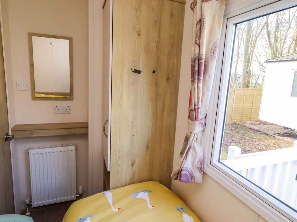A bedroom with a bed and wardrobe at Sunflower Retreat, Caravan 61